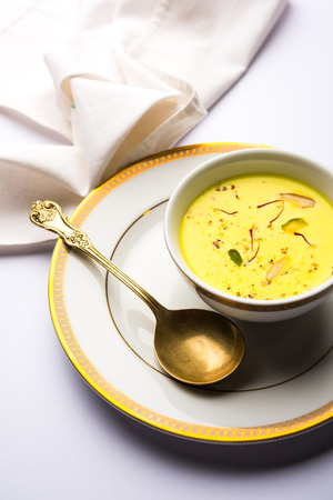Basundi Or Rabri is an Indian sweet popular in Gujarat and Maharashtra. It is a sweetened condensed milk. Garnished with Dry fruits and Saffron. Served in a bowl over moody background. Selective focusの写真素材