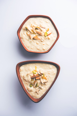 Sweet Rabdi or Lachha Rabri or basundi, made with pure milk garnished with dry fruits. Served in a bowl over moody background. Selective focusの写真素材