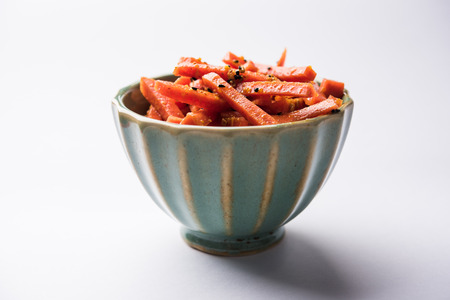 Carrot Pickle / Gajar ka Achar or Loncha in hindi. Served in a bowl over moody background. Selective focusの写真素材