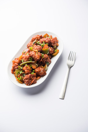 Indian Chilli Chicken dry, served in a plate over moody background. Selective focusの写真素材