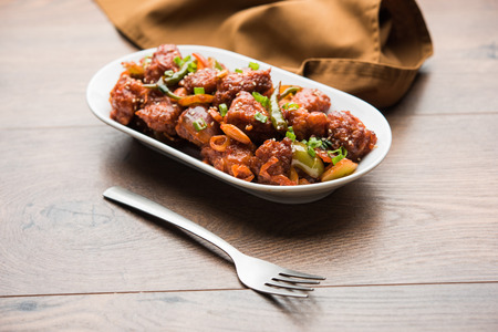 Indian Chilli Chicken dry, served in a plate over moody background. Selective focusの写真素材