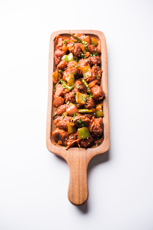 Indian Chilli Chicken dry, served in a plate over moody background. Selective focusの写真素材