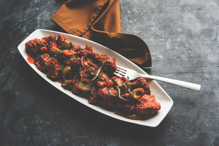 Indian Chilli Chicken dry, served in a plate over moody background. Selective focusの写真素材