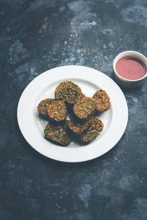 Cilantro cake or Kothimbir Vadi is a popular maharashtrian cuisine made with cilantro leaves. served with tomato ketchup. selective focusの写真素材