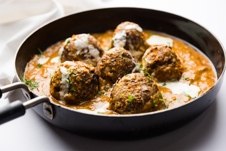 Malai Kofta is a Mughlai Speciality dish served in a bowl or pan over moody background. selective focusの写真素材