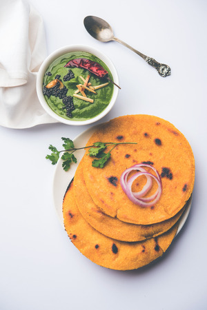 Makki di roti with sarson ka saag, popular punjabi main course recipe in winters made using corn breads mustard leaves curry. served over moody background. selective focusの写真素材