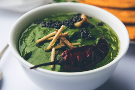 Makki di roti with sarson ka saag, popular punjabi main course recipe in winters made using corn breads mustard leaves curry. served over moody background. selective focusの写真素材