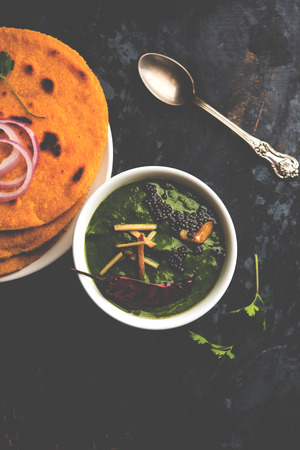 Makki di roti with sarson ka saag, popular punjabi main course recipe in winters made using corn breads mustard leaves curry. served over moody background. selective focusの写真素材