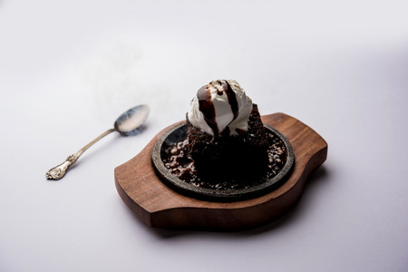 sizzling chocolate brownie is a sweet dish made using scoop of ice-cream on top served with a generous pouring of melted chocolate. server hot. selective focusの写真素材
