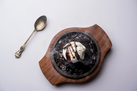 sizzling chocolate brownie is a sweet dish made using scoop of ice-cream on top served with a generous pouring of melted chocolate. server hot. selective focusの写真素材