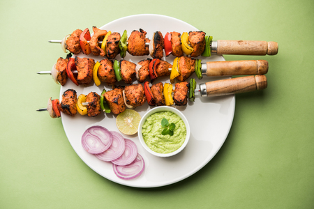 Indian chicken tikka kebabs, marinated in spices and yogurt and roasted in tandoor. served with green chutney and onion. selective focusの写真素材