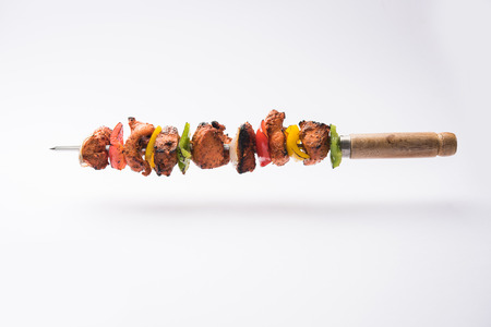 grilled chicken tikka on skewers.  served in a plate with green chutney and onion. Selective focusの写真素材