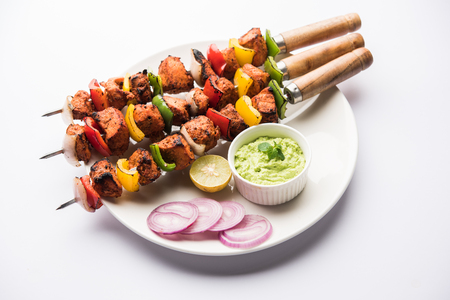 Indian chicken tikka kebabs, marinated in spices and yogurt and roasted in tandoor. served with green chutney and onion. selective focusの写真素材