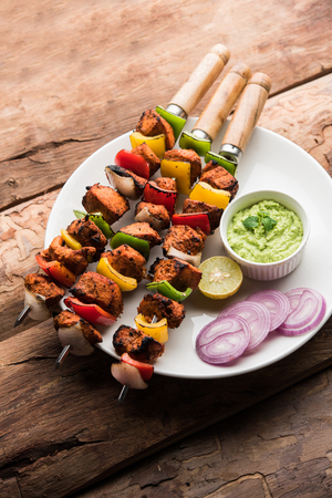 Indian chicken tikka kebabs, marinated in spices and yogurt and roasted in tandoor. served with green chutney and onion. selective focusの写真素材