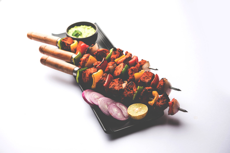 Indian chicken tikka kebabs, marinated in spices and yogurt and roasted in tandoor. served with green chutney and onion. selective focusの写真素材