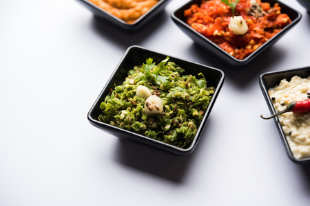 Group of Indian Chutneys includes coconut, Peanut, green and red chilly, garlic and pudina served in small square shape bowls. selective focusの写真素材