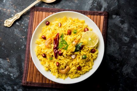 Lemon Rice is a South Indian turmeric rice or maharashtrian recipe called fodnicha bhat using leftover rice garnished with nuts curry leaves and lemon juice, selective focusの写真素材