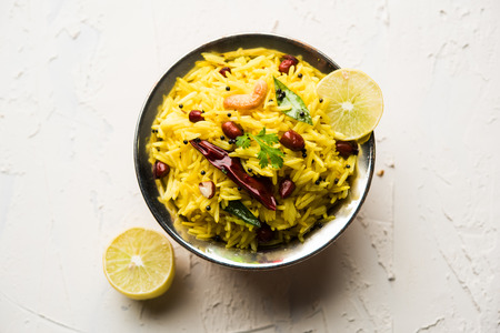 Lemon Rice is a South Indian turmeric rice or maharashtrian recipe called fodnicha bhat using leftover rice garnished with nuts curry leaves and lemon juice, selective focusの写真素材