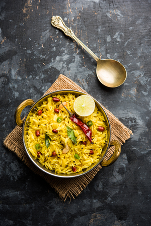 Lemon Rice is a South Indian turmeric rice or maharashtrian recipe called fodnicha bhat using leftover rice garnished with nuts curry leaves and lemon juice, selective focusの写真素材