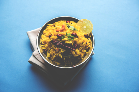 Lemon Rice is a South Indian turmeric rice or maharashtrian recipe called fodnicha bhat using leftover rice garnished with nuts curry leaves and lemon juice, selective focusの写真素材