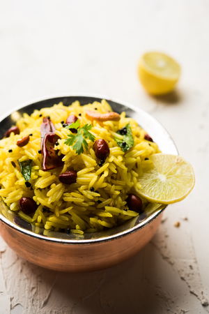 Lemon Rice is a South Indian turmeric rice or maharashtrian recipe called fodnicha bhat using leftover rice garnished with nuts curry leaves and lemon juice, selective focusの写真素材