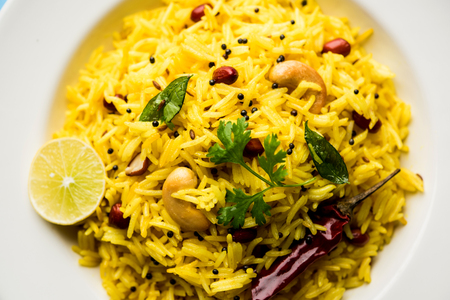 Lemon Rice is a South Indian turmeric rice or maharashtrian recipe called fodnicha bhat using leftover rice garnished with nuts curry leaves and lemon juice, selective focusの写真素材
