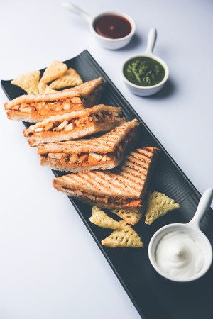 Paneer tikka Sandwich - is a popular Indian version of sandwich using cottage cheese curry with tomato ketchup, mint chutneyの写真素材