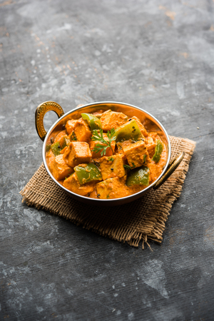 Malai or achari Paneer in a gravy made using red gravy and green capsicum. served in a bowl. selective focusの写真素材
