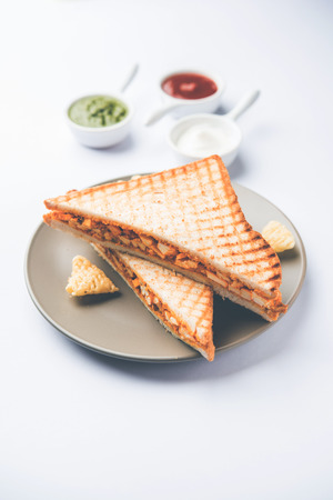 Paneer tikka Sandwich - is a popular Indian version of sandwich using cottage cheese curry with tomato ketchup, mint chutneyの写真素材