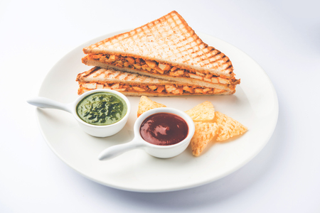 Paneer tikka Sandwich - is a popular Indian version of sandwich using cottage cheese curry with tomato ketchup, mint chutneyの写真素材