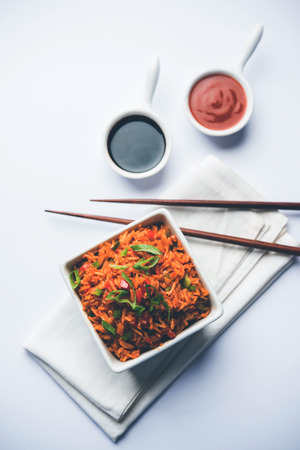 Schezwan Fried Rice Masala is a popular indo-chinese food served in a plate or bowl with chopsticks. selective focusの写真素材