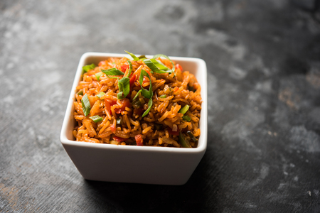Schezwan Fried Rice Masala is a popular indo-chinese food served in a plate or bowl with chopsticks. selective focusの写真素材