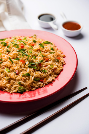 Schezwan Fried Rice Masala is a popular indo-chinese food served in a plate or bowl with chopsticks. selective focusの写真素材