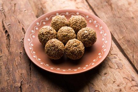 Tilgul Laddu or Til Gul balls for makar sankranti, it's a healthy food made using sesame, crushed peanuts and jaggery. served in a bowl. selective focus showing details.の写真素材