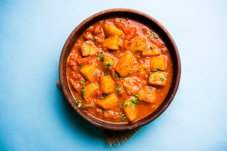 Indian food - Aloo curry masala. Potato cooked with spices and herbs in a tomato curry. served in a bowl over moody background. selective focusの写真素材