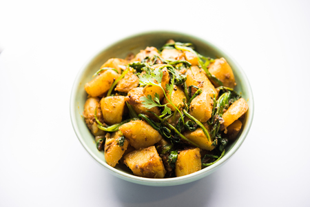 Aloo Palak sabzi - Potato cooked with spinach with added spices. a healthy Indian main course recipe. Served in a bowl, selective focusの写真素材