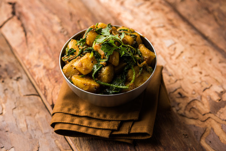 Aloo Palak sabzi - Potato cooked with spinach with added spices. a healthy Indian main course recipe. Served in a bowl, selective focusの写真素材