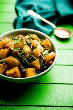 Aloo Palak sabzi - Potato cooked with spinach with added spices. a healthy Indian main course recipe. Served in a bowl, selective focusの写真素材