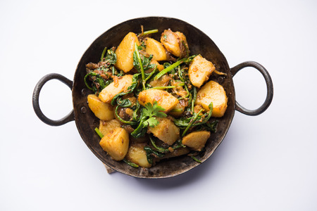 Aloo Palak sabzi - Potato cooked with spinach with added spices. a healthy Indian main course recipe. Served in a bowl, selective focusの写真素材