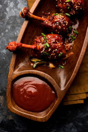 Szechuan Chicken which is a popular Indo-Chinese non vegetarian recipe. served in a plate with chilli sauce. selective focusの写真素材