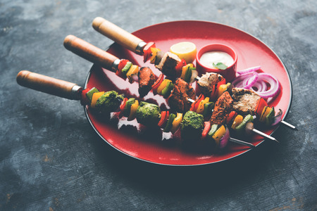 Chicken Hariyali kakab or Malai malai kebab served with skewers and yogurt dip in a plate. selective focusの写真素材