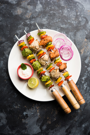 Chicken Hariyali kakab or Malai malai kebab served with skewers and yogurt dip in a plate. selective focusの写真素材