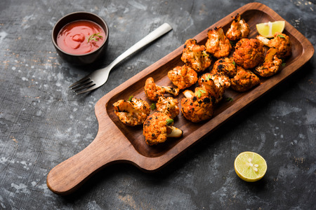 Tandoori Gobi / Roasted cauliflower Tikka is a dry dish made by roasting Cauliflowers in Oven/Tandoor. It's  popular starter food from India. served with ketchup. selective focusの写真素材