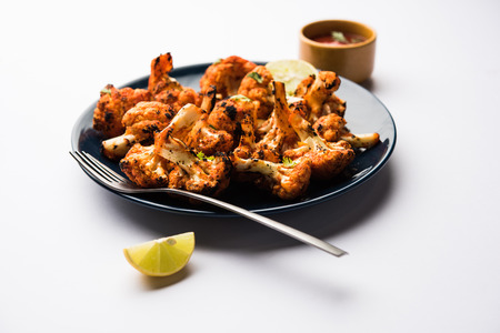 Tandoori Gobi / Roasted cauliflower Tikka is a dry dish made by roasting Cauliflowers in Oven/Tandoor. It's  popular starter food from India. served with ketchup. selective focusの写真素材