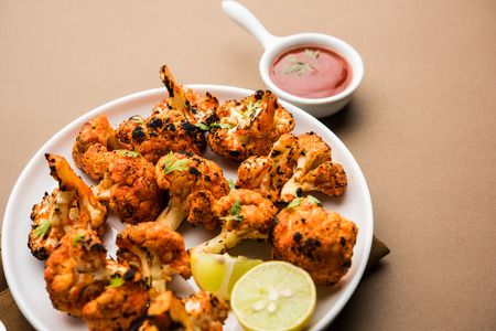 Tandoori Gobi / Roasted cauliflower Tikka is a dry dish made by roasting Cauliflowers in Oven/Tandoor. It's  popular starter food from India. served with ketchup. selective focusの写真素材