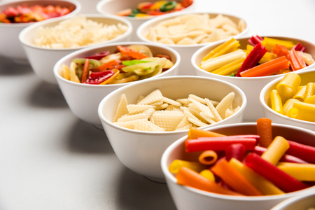 Snack pellets are non-expanded products made with raw materials like cereals, potatoes or vegetable powders, later processed using frying, hot air baking. multicoloured / shaped ready-to-eat snacksの写真素材
