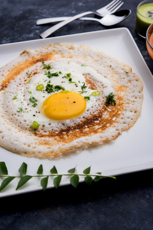 Egg Dosa is a popular south indian non-vegetarian breakfast or meal, served with sambar and chutneyの写真素材