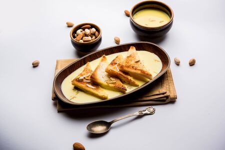 Shahi tukra/tukda or Double ka meetha is a bread pudding Indian sweet of fried bread slices soaked in rabid or sweet saffron milk garnished with dry fruitsの写真素材