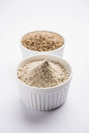 Bajra (pearl millet) / sorghum grains with it's flour or powder in a bowl, selective focusの写真素材