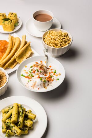 Group of Gujarati snacks like jalebi-fafda, thepla, khaman dhokla, aloo bhujiya, khandvi,khakra, dahi vada, gathiya with hot teaの写真素材